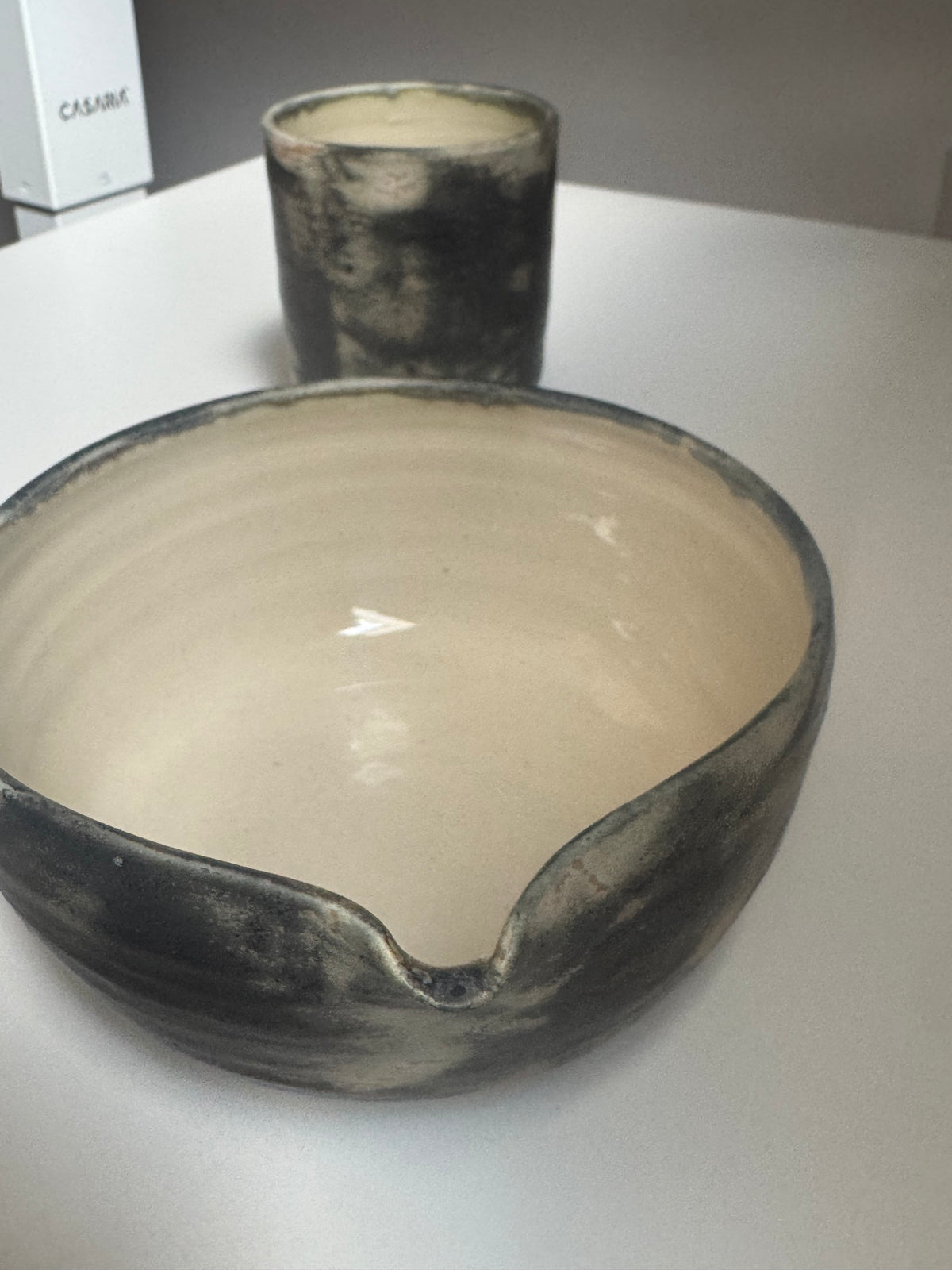 The Pouring Bowl Graphite — charcoal rim, cream interior, handmade in Málaga
